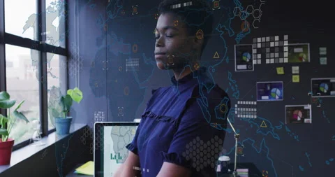 Data analyst by window viewing bar graph on computer initiating map overlays Stock Footage 314719236