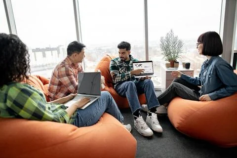 Data analysts looking at laptop with charts in workplace Stock Photos