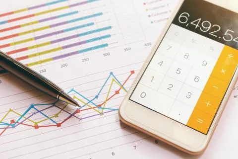 Data analyzing with calculator mobile phone and pen. from charts and graph .. Stock Photos