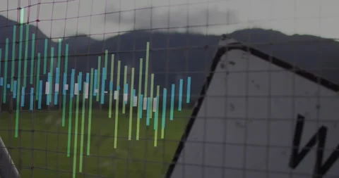 Data bars animating across wire mesh fence, showing grassy field and mountain Stock Footage 327003438