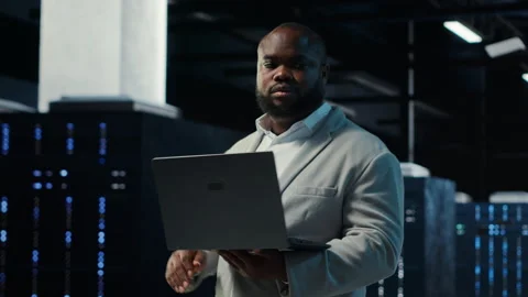 Data center admin coding, writing script on laptop, identifying bottlenecks Stock Footage 311898663
