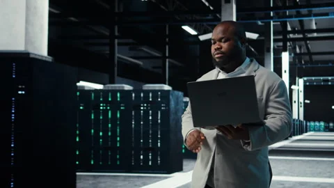 Data center admin coding, writing script on laptop, identifying bottlenecks Stock Footage 311963263