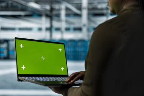 Data center admin conducts tests on infrastructure using green screen laptop Stock Photos