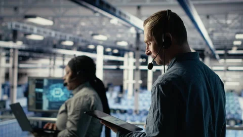 Data center admin talking in audio headset mic, helping clients Stock Footage 314685926