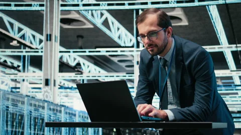 Data center admin typing on laptop keyboard, doing resource optimization Video stock 329532085