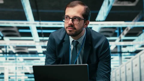 Data center admin typing on laptop keyboard, doing resource optimization Video stock 329944776