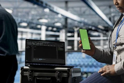 Data center admin uses mockup phone, waits for coding script to finish, closeup 스톡 사진