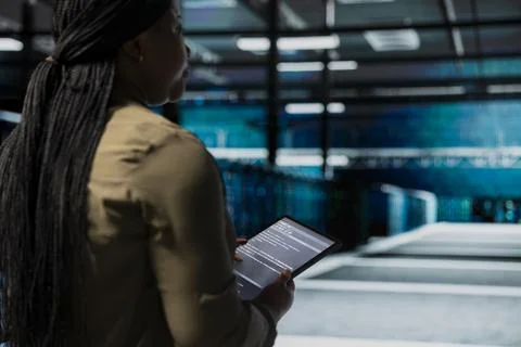 Data center admin uses tablet to monitor hardware for potential failures Stock Photos