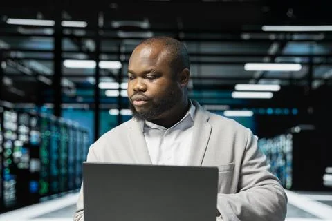 Data center admin using laptop, preparing recovery backups Stock Photos