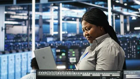 Data center admin using laptop to do node tree programming Stock-Fotos