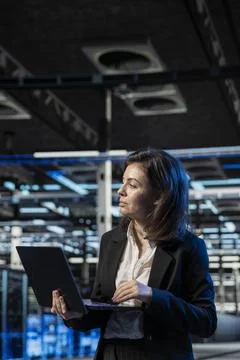 Data center admin using laptop to install and configure equipment Stock Photos