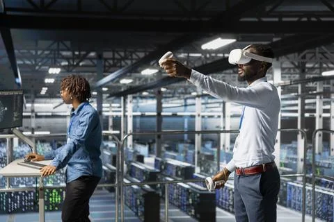 Data center admin using VR glasses to monitor neural network AI systems Stock Photos