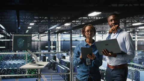 Data center admins running diagnostics on equipment, doing brainstorming 스톡 사진