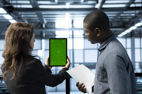 Data center admins using isolated screen tablet to calibrate energy usage Stock Photos
