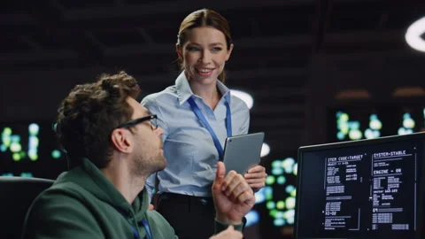 Data center analysts working in dark server room closeup. Programmers discussing Stock Footage 260259301