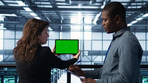 Data center colleagues using green screen chroma key device to monitor facility 写真素材