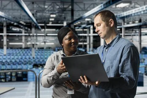 Data center computer scientists doing brainstorming, using laptop Foto stock