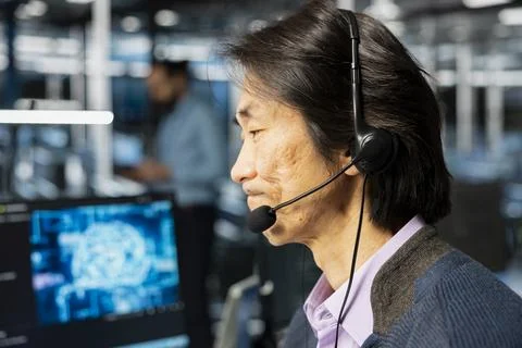 Data center developer doing tech support, talking in mic, adjusting parameters Stockfoto's