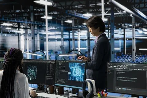 Data center developer monitors AI systems, adjusting machine learning parameters Stockfoto's