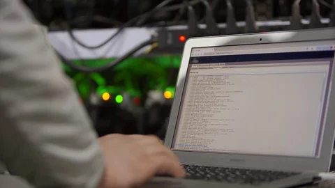 Data center diagnostics technician works and types on laptop. Mining equipment Stock Footage 130060200