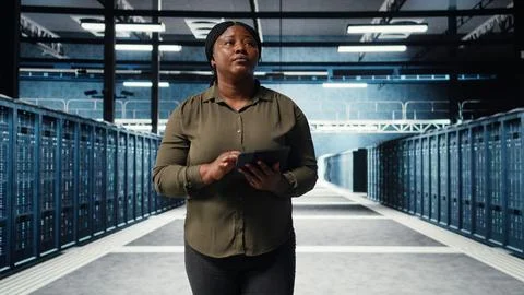 Data center employee uses tablet to manage software updates for system stability Stock Photos