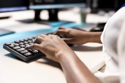 Data center employees typing on PC keyboard, creating technical documentation Stock Photos