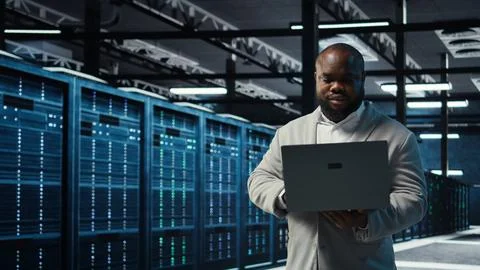 Data center engineer analyzing equipment performance, resolving technical issues Stock Photos
