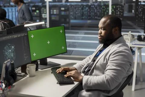 Data center engineer analyzing software logs metrics on green screen mockup PC Foto stock