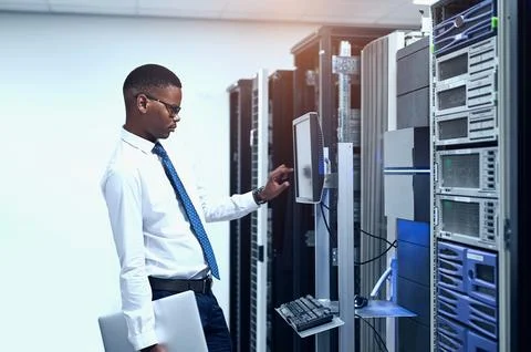 Data center, engineer and black man with pc in server room for information Stock Photos