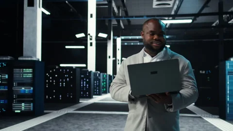 Data center engineer coding on laptop, doing software updates for mainframes Stock Footage 311960958