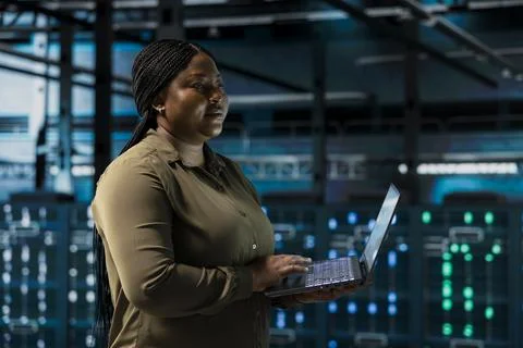 Data center engineer conducting tests on equipment using software Stock Photos