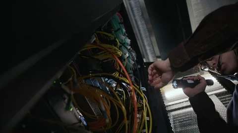 Data Center Engineer Inspecting Network Hardware with Flashlight Stock Footage 330539589