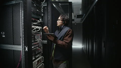 Data Center Engineer Maintaining Server Rack with Tablet Stock Footage 330542419