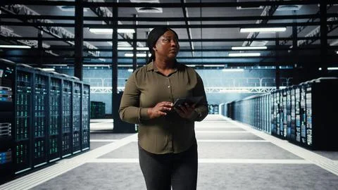 Data center engineer monitors data center metrics on tablet Stockfoto's