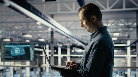 Data center engineer monitors machine learning process with laptop Stock Footage 314685447
