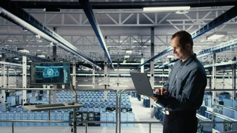 Data center engineer monitors machine learning process with laptop Stock Footage 314806098