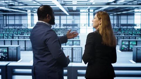 Data center engineer presenting equipment to inspector supervising operations Foto stock