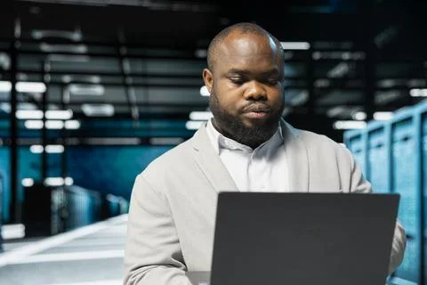 Data center engineer running error checking utilities on laptop Foto stock