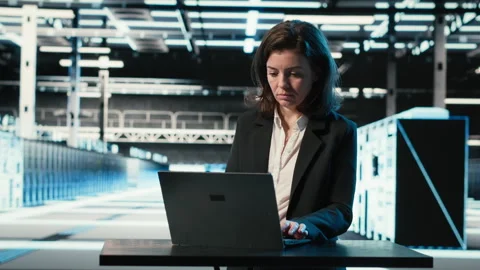 Data center engineer typing on laptop keyboard to troubleshoot issues Stock Footage 329323613