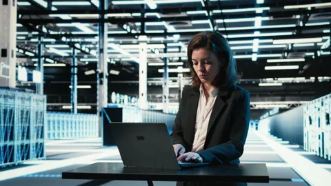Data center engineer typing on laptop keyboard to troubleshoot issues Stock Footage 330099792