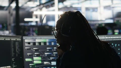 Data center engineer using algorithms to analyze datasets, putting on headphones Stock Photos