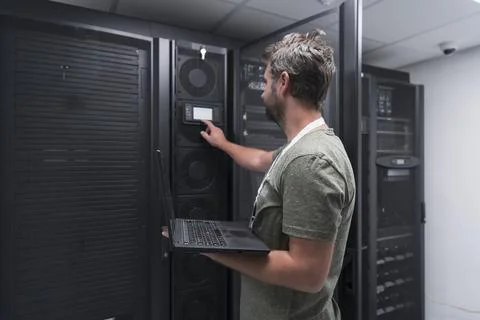 Data Center Engineer Using Laptop Computer Server Room Specialist Facility with Stock Photos