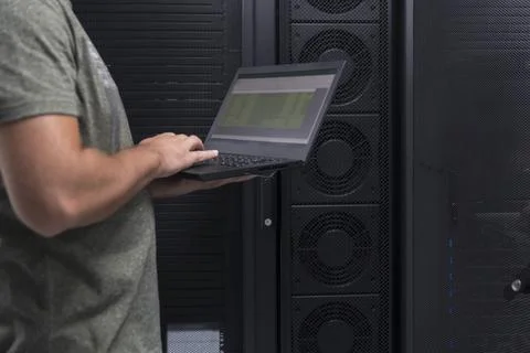 Data Center Engineer Using Laptop Computer. Server Room Specialist Facility with Stock Photos
