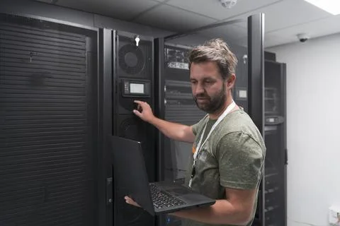 Data Center Engineer Using Laptop Computer Server Room Specialist Facility with Stock Photos
