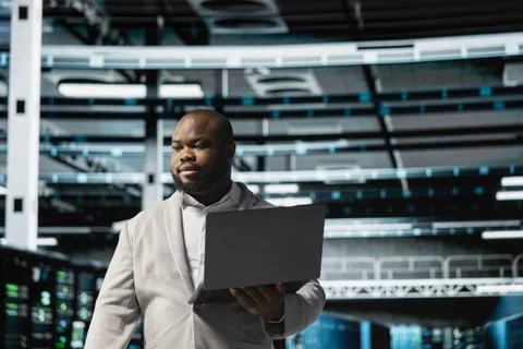 Data center engineer using laptop to troubleshoot backend operations Stock Photos