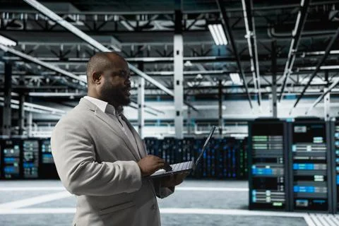 Data center engineer using laptop to automate errors detection Foto stock