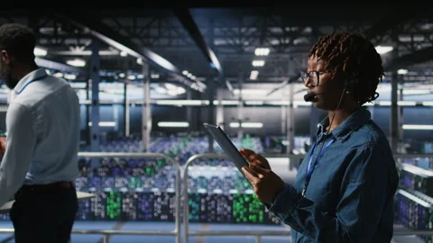 Data center engineer wearing headset microphone providing remote diagnostics Stock Footage 310784945