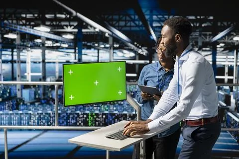 Data center engineers on industrial platform using isolated screen on pc Stock Photos