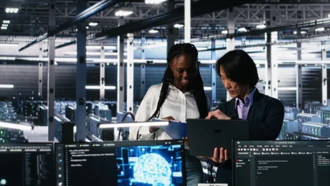 Data center engineers managing AI systems, looking over paperwork Stock Footage 313567072