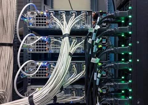 Data center equipment with organized cabling and illuminated ports providing Stock Photos